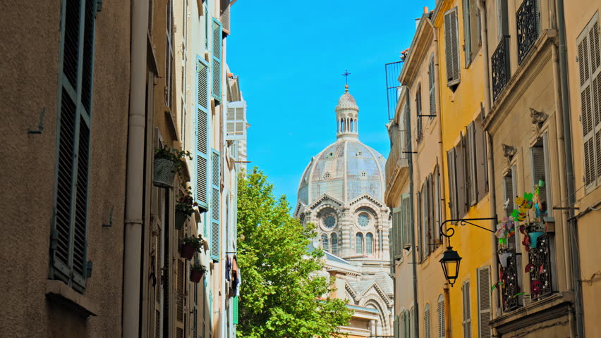 Narrow streets of the old town Marseille with the view of Basilica. Colorful houses and buildings in Marseille.