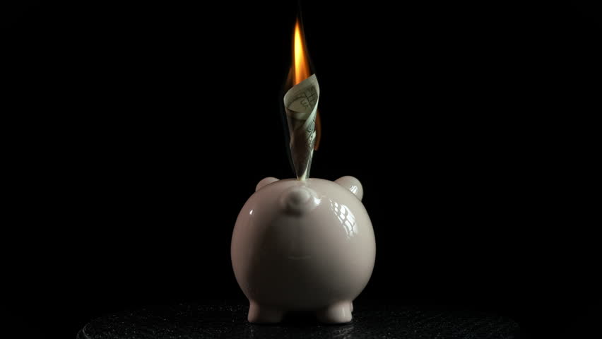 Burning home bank on black background. A view of dollars in fire in piggy bank. A concept of finance crisis in the world. Royalty-Free Stock Footage #1107103177