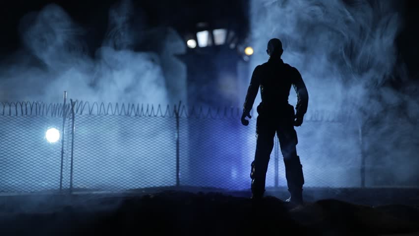Criminal justice imprisonment concept or prison break concept. Silhoette of prisoner standing near of prison fence with watchtower at night. Creative art decoration. Selective focus Royalty-Free Stock Footage #1107104313