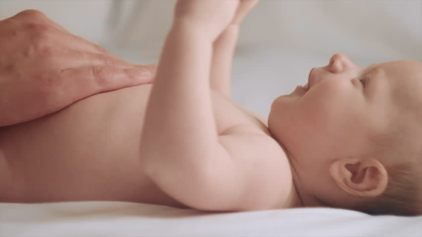 Close-up of father hands massaging little baby. Newborn Baby skin care concept. Prevention of colic. Male hands doing massage to newborn. Nice caucasian infant baby lying on cozy bed. Slow motion Royalty-Free Stock Footage #1107113709