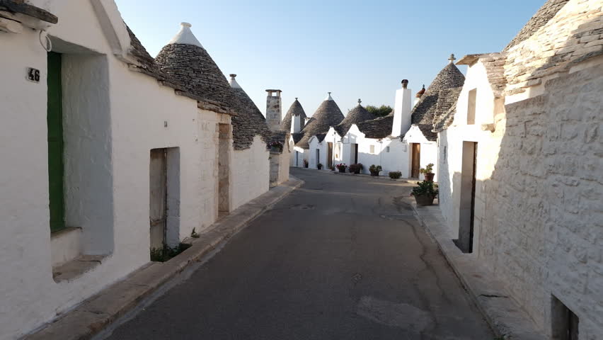 Alberobello Italy - traditional trulli houses with conical stone roofs. Famous landmark, travel destination and tourist attraction near Bari in Puglia, Europe. Street with ancient architecture. Royalty-Free Stock Footage #1107117035