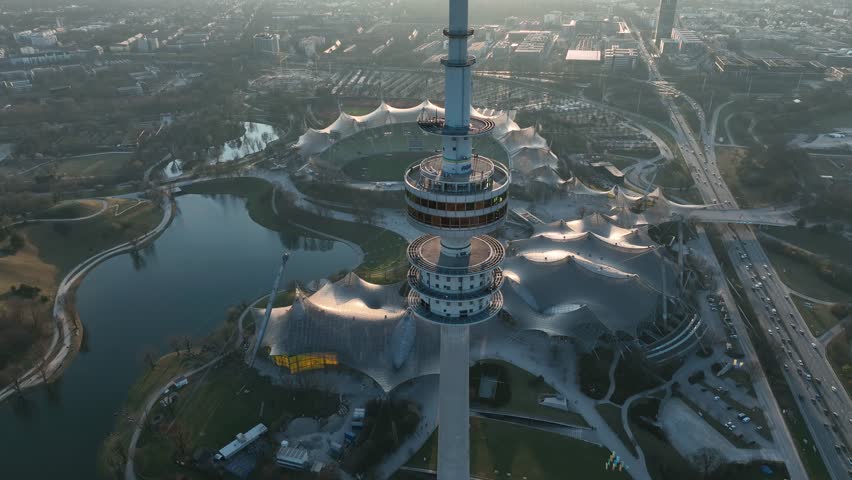 The drone is flying around the olimpic tower during sunset with olimpia park in the background in Munich Germany Aerial Drone Footage 4k Royalty-Free Stock Footage #1107126967