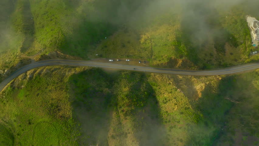 Aerial top down drone shot above the winding mountain road between the trees. Malibu. Aerial view white car travels in beautiful mountainous terrain. Aerial vertical, vertical video background. Royalty-Free Stock Footage #1107127507