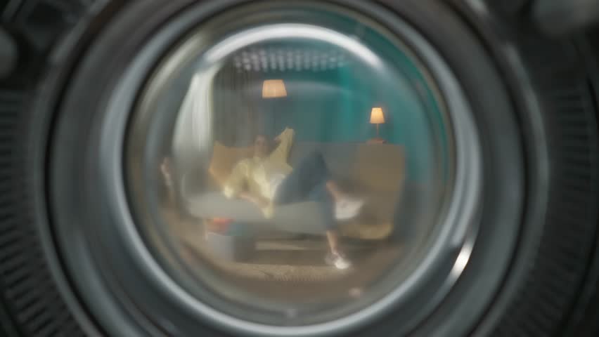View from inside the empty washing machine, young couple having fun time while doing laundry Royalty-Free Stock Footage #1107131317