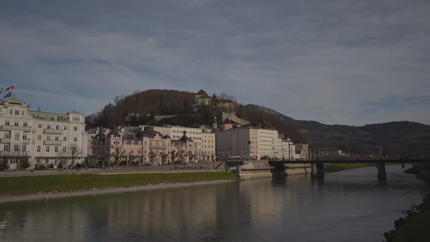 Salzburg, Austria. Cityscape over river in Salzburg on sunny winter day. Salzach riverfront. Embankment of Salzach river in Salzburg old town, Austria, Europe. Town view