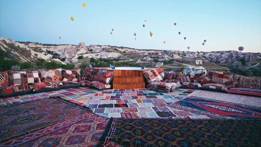 The beautiful and charming terrace with colorful hand made carpets and hot air balloons flying over Red valley in background. 8K
Cappadocia , Turkey Royalty-Free Stock Footage #1107136165