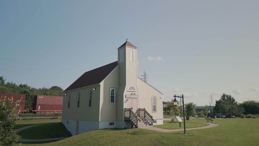 Drone shot between trees at Africville Museum Picturesque Church Halifax, Canada. The wooden old church on the ocean is the historical value of Canada.