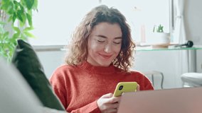 Smiling young woman sitting on couch using cell phone, happy lady holding laptop, looking at cellphone doing online shopping in mobile apps ordering ecommerce products or checking social media. - Powered by Shutterstock - Get 15% off with code: PIKWIZARD15