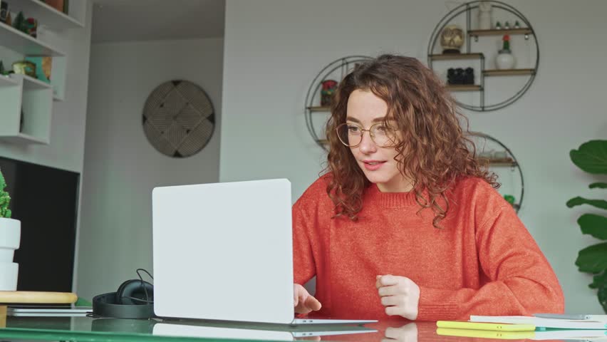 Happy girl student winner looking at laptop receiving good news in email celebrating achievement success. Excited woman winning online, getting new approved job opportunity using computer at home. Royalty-Free Stock Footage #1107145427