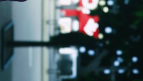 Vertical video Asian person walking around town under streetlights, enjoying urban promenade near city center district. Young woman relaxing on stroll at nighttime, admiring downtown and skyscrapers - Powered by Shutterstock - Get 15% off with code: PIKWIZARD15