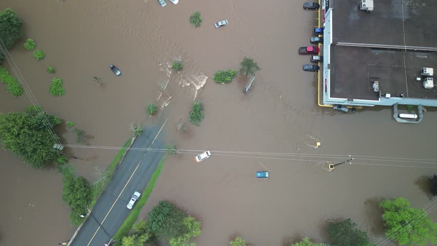 Top View of the Small Town of Bedford Being Flooded by Heavy Rain and Storm Weather. Flooded Area in Canada 2023. Houses Overflowing with Water, Cars in the Parking Lot of Shops Under Water.