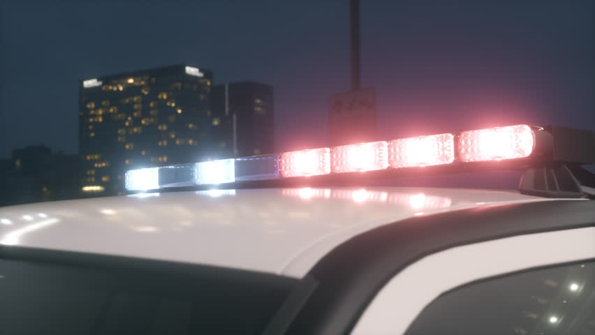 Police car lights glowing, emergency signal flashing during night.
