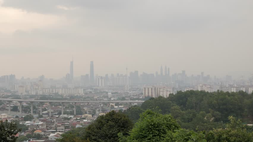 horizontal wide city central landscape view of many skyscraper highrise modern style buildingin Kuala lumpur,KL city, Malaysia with some smog pollution in sunset time,asia cityscape with pollution Royalty-Free Stock Footage #1107149955