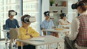 Experience augmented reality in a school. Teacher with pupils wearing VR glasses to watch videos and study together. People and technology concept - Powered by Shutterstock - Get 15% off with code: PIKWIZARD15