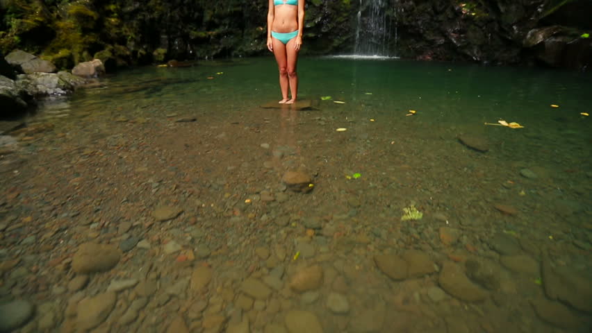 Attractive Young Brunette Woman Under a Beautiful Hawaiian Waterfall