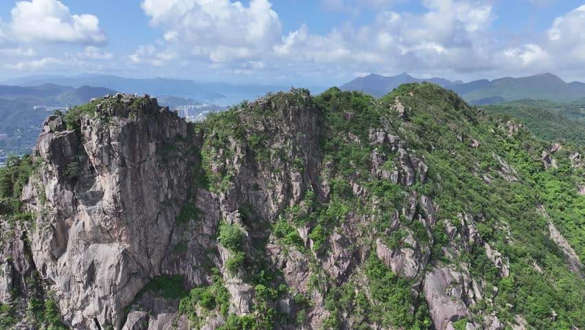 Lion Rock mountain in Kowloon Peninsula Hong Kong sunny aerial drone skyview shot. Popular travel destination in Asia. China. Rock climbing cliffs