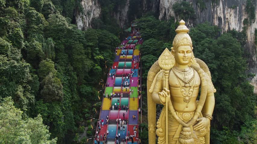 Aerial drone shot of Batu Caves temple and the giant Murugan statue, Hindu God of war, in Kuala Lumpur, Malaysia. Royalty-Free Stock Footage #1107161179
