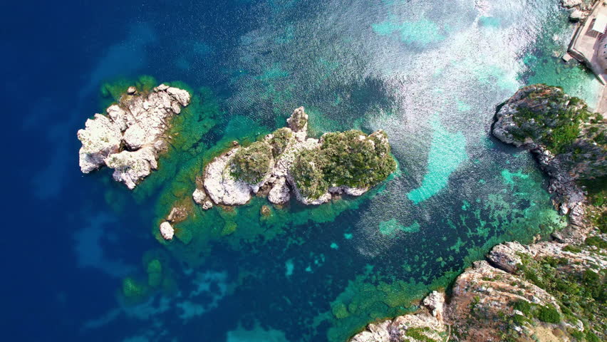 Sicily 2023. Aerial view of the sea stacks of Scopello and the crystalline sea. We are near a famous tuna fishery (Almadraba) and the nature reserve called "Dello Zingaro". May 2023 Trapani, Italy Royalty-Free Stock Footage #1107167583