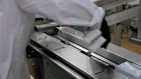 Line for production of dairy products at modern factory. Finished products made of butter or ice cream are moved along tape in briquettes. Worker puts ready briquettes of delicious desserts on tape - Powered by Shutterstock - Get 15% off with code: PIKWIZARD15