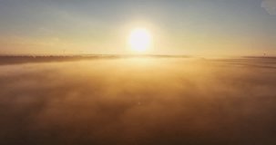 Aerial sunrise view over fog sky with clouds and agronomy fields of wheat plants, sunrise flight with sunlight 4K video