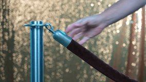 A bouncer unhooks and hooks a velvet rope, perhaps at a disco or night club.  	 - Powered by Shutterstock - Get 15% off with code: PIKWIZARD15