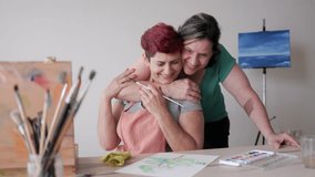 Happy gay senior couple painting with watercolors together at home studio - Elderly relationships and lgbt family - Powered by Shutterstock - Get 15% off with code: PIKWIZARD15