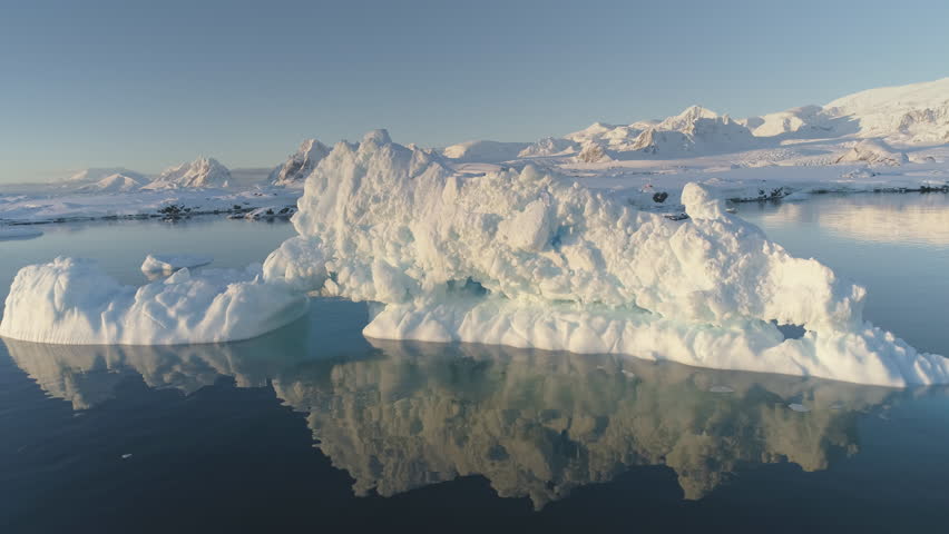 Melting ice - Global Warming. Iceberg Reflection in Slow Motion. Go Down View of Huge Ice Floe Melt in Clear Ocean Winter Water. Climate Concept. South Pole Majestic Panorama Drone Flight Shot. 4K UHD | Shutterstock HD Video #1107180277