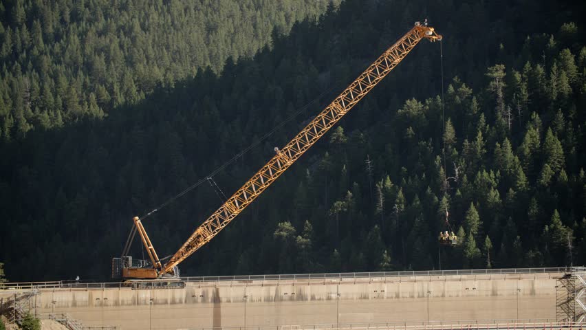 A construction crane working on the dam at Gross Reservoir in Boulder County, Colorado, USA. Pan right tele shot