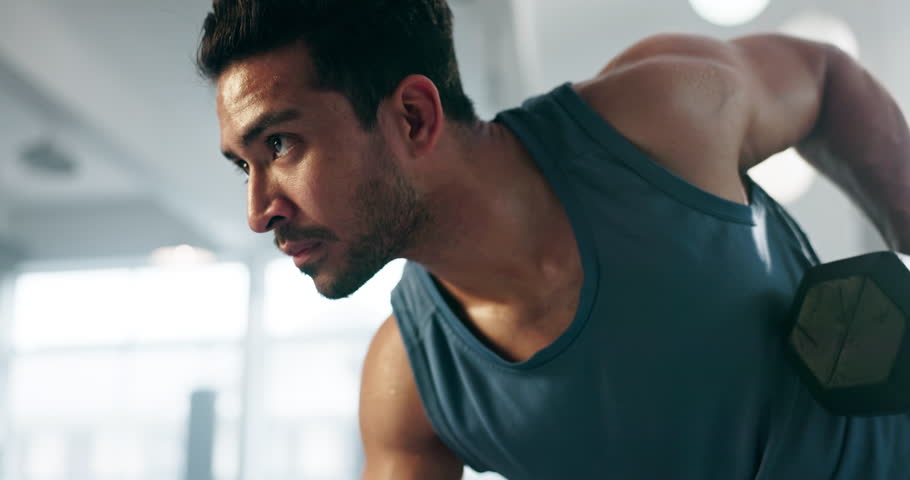 Fitness, dumbbell exercise and a man at gym for body builder training and wellness. Profile of serious Asian person with focus for power, strong muscle and workout for athlete motivation and health