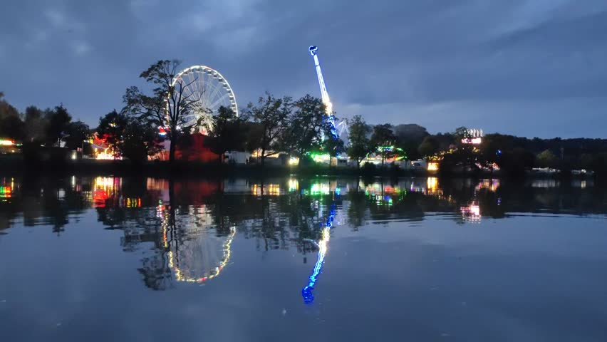 Summer Fest with Carousels next to river Danube in Ulm at night.