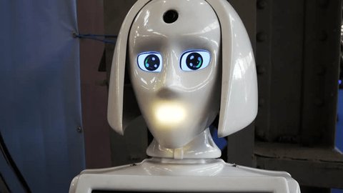 The white robot talks, turns its head and rotates its eyes. Artificial intelligence as a human assistant, a robot manager. Video stock