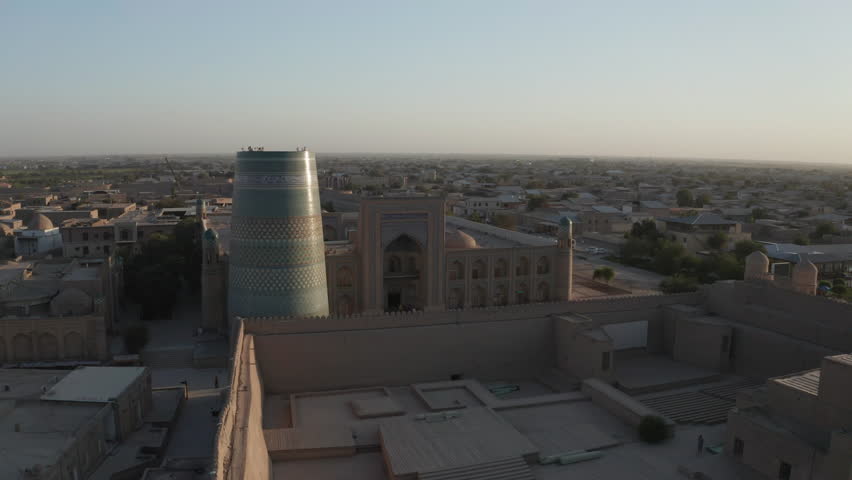 Aerial drone point of the Itchan Kala and Alla Kouli Khan Madrasa at the old walled city of Khiva in Uzbekistan. Royalty-Free Stock Footage #1107186987