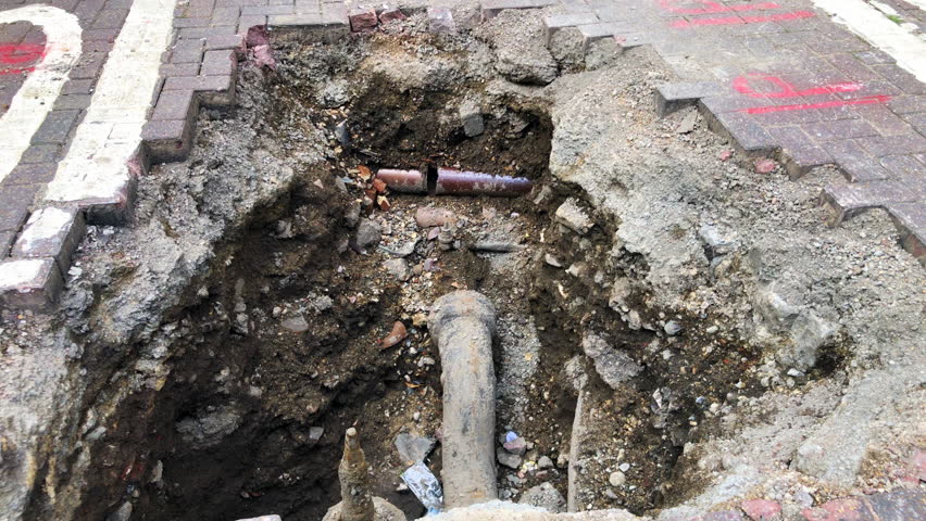 London, UK, August 1st 2023:A London City road, closed for emergency underground pipe repairs.   Concept for water drainage pipes, sewer pipes, underground broken pipe and road works. `Static shot.