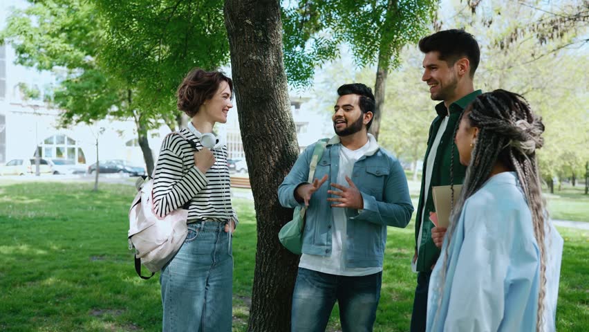 Positive multicultural young student friends talking in park Royalty-Free Stock Footage #1107188193