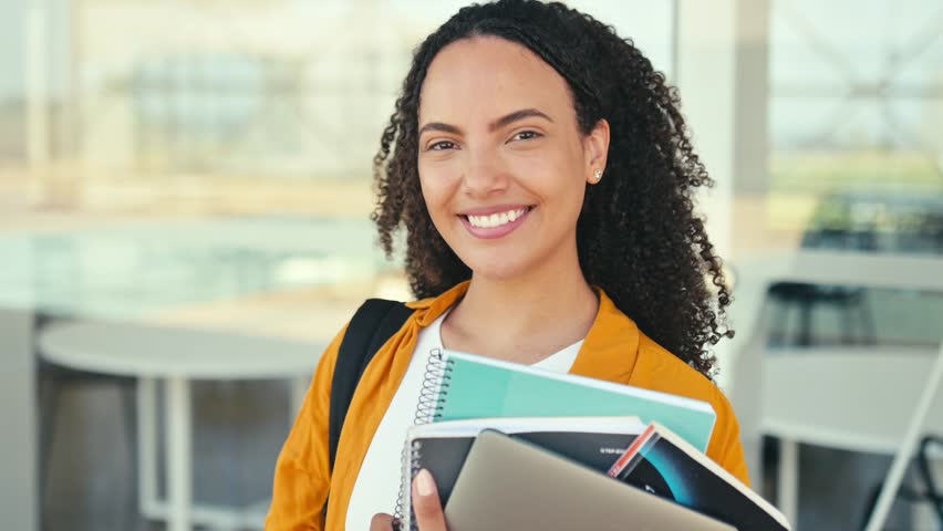 Positive trendy female student. Happy lovely brazilian or hispanic female student, with a backpack, hold books and notebooks in her hand, stand near the university campus, looks and smile at camera Royalty-Free Stock Footage #1107191041
