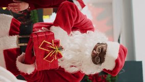 Vertical video Customers participating in Christmas raffle hold by employee dressed as Santa Claus in clothing store. Asian woman excited after winning winter holiday season promotional fashion shop