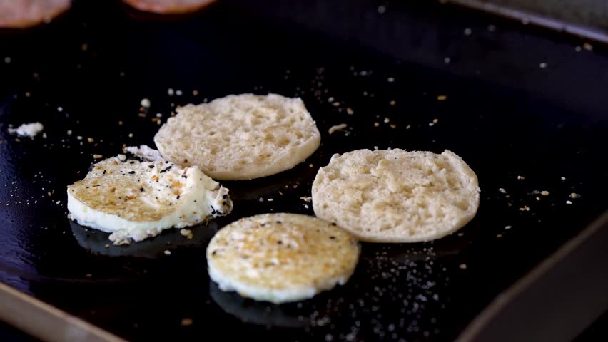 Breakfast sandwich being put together on a hot cast iron griddle. Royalty-Free Stock Footage #1107194527