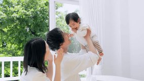 Parents lifting a baby in front of fresh green. Parenting concept. - Powered by Shutterstock - Get 15% off with code: PIKWIZARD15