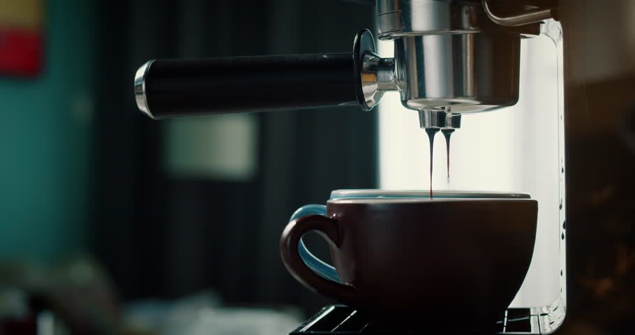 Pouring coffee stream from machine in red and broun cup. Home making hot Espresso. Using filter holder. Flowing fresh ground coffee. Drinking roasted black coffee in the morning. 4K