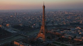 The drone is going around the eiffel tower during golden hour at daytime in Paris France Aerial Footage 4K