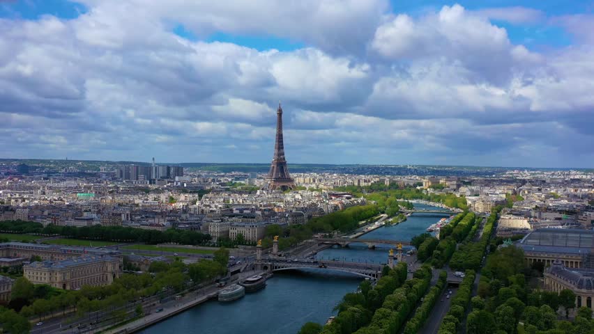The drone is flying towards the eiffel tower over the Seine with the sun shining in Paris France Aerial Footage 4K