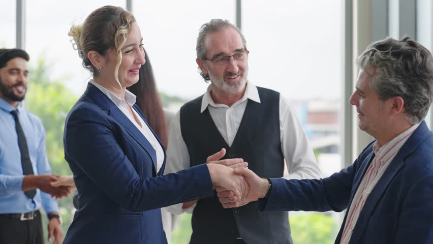 Caucasian man leader introducing woman manager to new team partner at seminar of company. Male leader introducing woman manager shaking hands welcoming newcomer