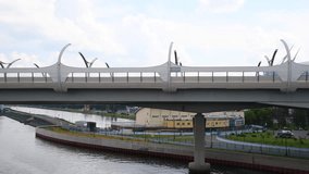 Side view of western high-speed diameter with bridge standing above river water in Saint Petersburg city, Russia. Cloudy sky. Real time video. Urban architecture theme.