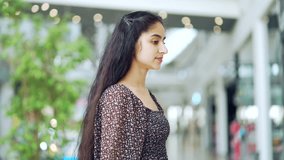 Young indian woman wearing a dress afraid and shocked with surprise expression, Close up portrait fear and excited face standing of shopping center mall store during Black Friday discounts and sales