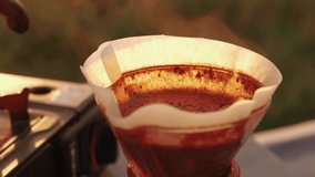 Close up video preparing pour over coffee outdoor in camping at sunrise
