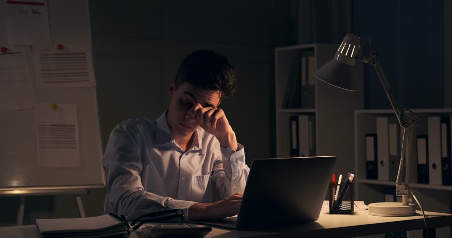 Disheartened and Weary Businessman Closing Laptop in Nighttime Office Royalty-Free Stock Footage #1107224045