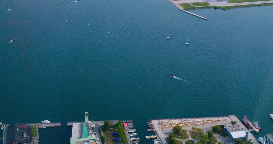 Top view from CN Tower to jetty of Lake Ontario, Canada. Slow motion shot of Lake Ontario, harbor with floating boats and ships. Enjoy view from top CN Tower to jetty of Lake Ontario with your friends