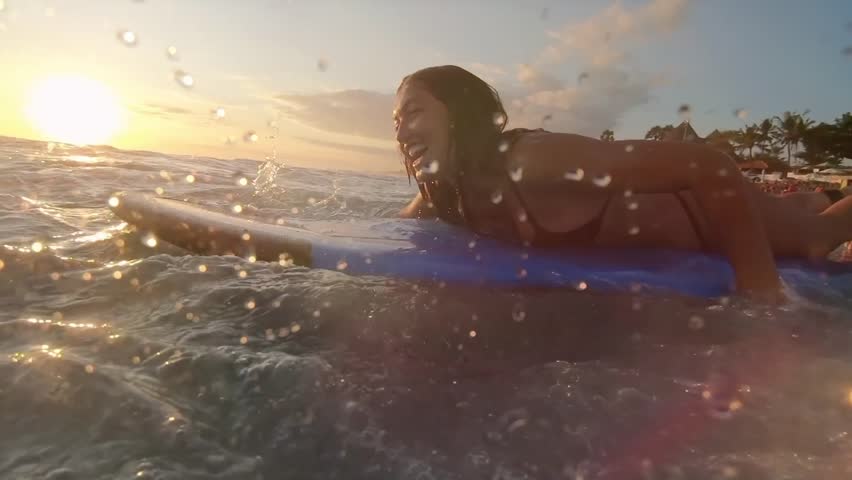 Surfing at Sunset. Outdoor Active Lifestyle. Portrait of surfer woman surfing having fun on Bali, Indonesia. Female bikini girl in water during surfing surfboard smiling happy living healthy lifestyle Royalty-Free Stock Footage #1107225219