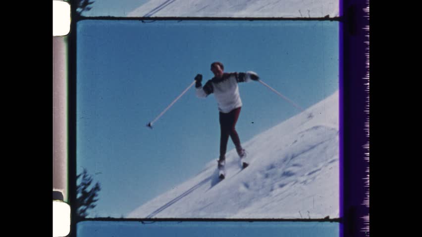 1984 Zermatt, Switzerland. Snow skier performs difficult trick, turning 360 degree one leg. Mogul skiing taking sharp turns on small mounds in competition. 4K Overscan vintage archival film 