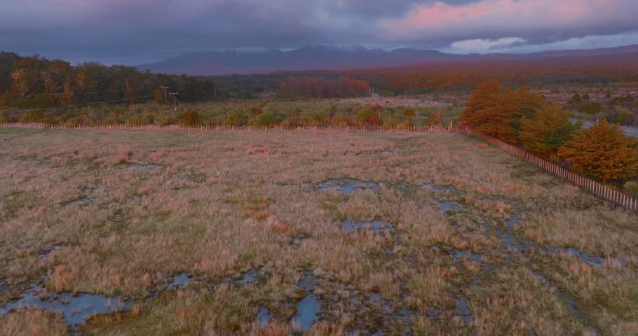 Aerial: Road in the Tongariro National Park and Mt Ngauruhoe volcano obscured by cloud, New Zealand